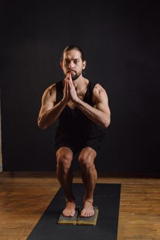 Man in yoga pose on bed of nails demonstrating balance and concentration.