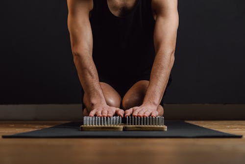 A Person Touching the Sadhu Board on the Yoga Mat