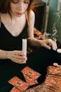 一个女人拿着蜡烛读塔罗牌，传达出一种神秘的气息