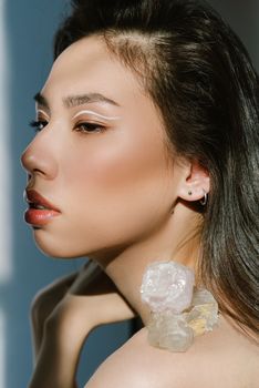 Close-up portrait of a woman with crystals and artistic eye makeup.