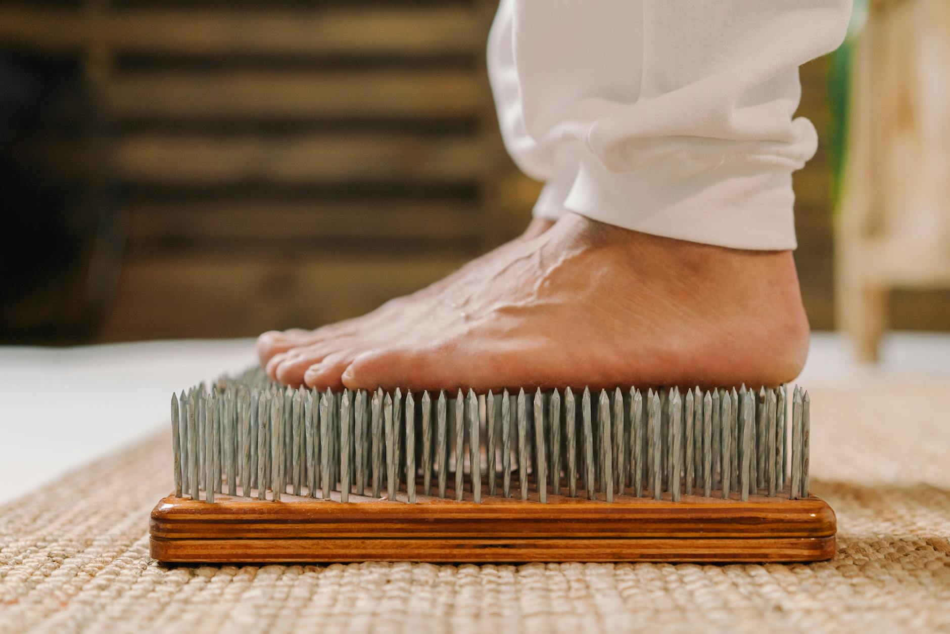 The Role of Risk in Growing Your Wealth: Understanding and Managing Potential Pitfalls 3 A close-up shot of a barefoot person standing on a nail board, used in meditation and pain tolerance practices.