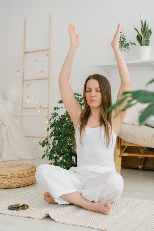 A Woman Meditating While Raising Her Arms