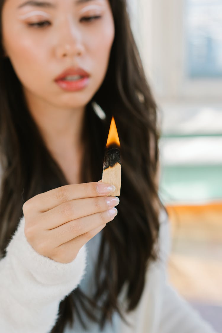 
A Woman Holding A Palo Santo