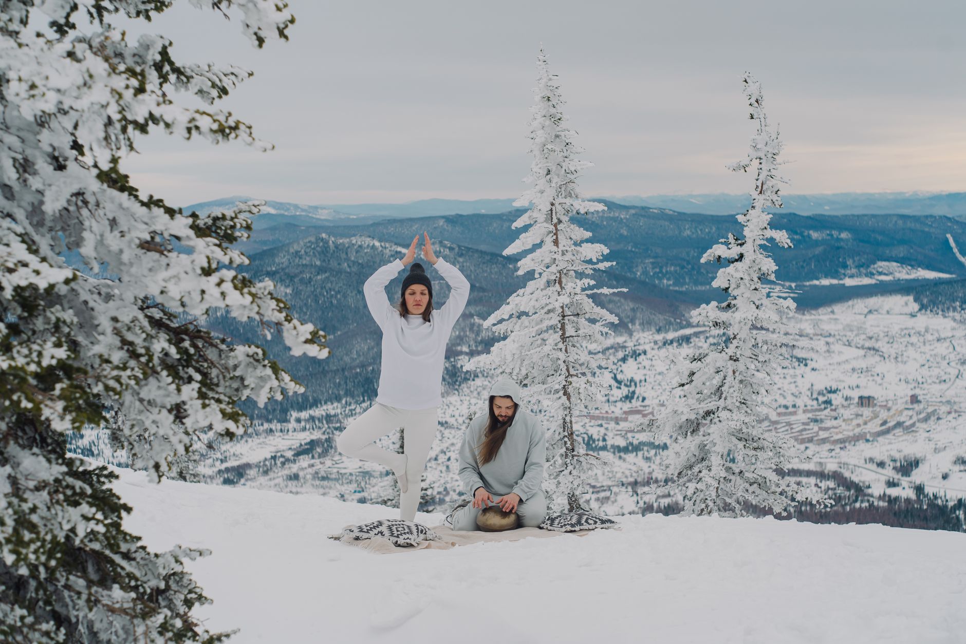 A serene yoga and meditation session in a snowy mountain landscape.
