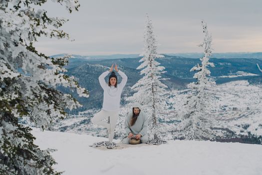 A serene yoga and meditation session in a snowy mountain landscape.