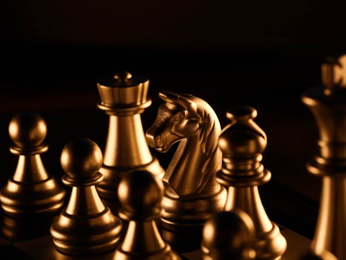 Gold Chess Pieces on Chess Board