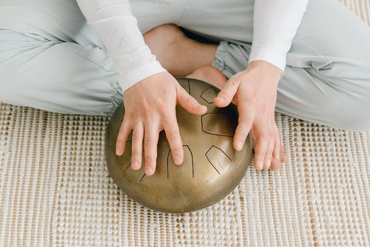 Woman Sitting On Floor With Hapi Drum