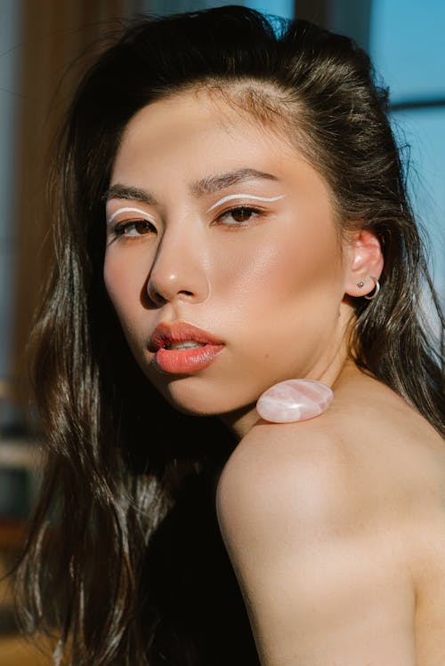 Asian female with stylish makeup and stone on shoulder