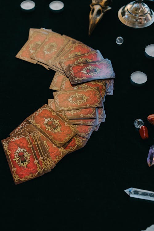 From above of fortune telling cards with candles and stones for seance and fortune telling