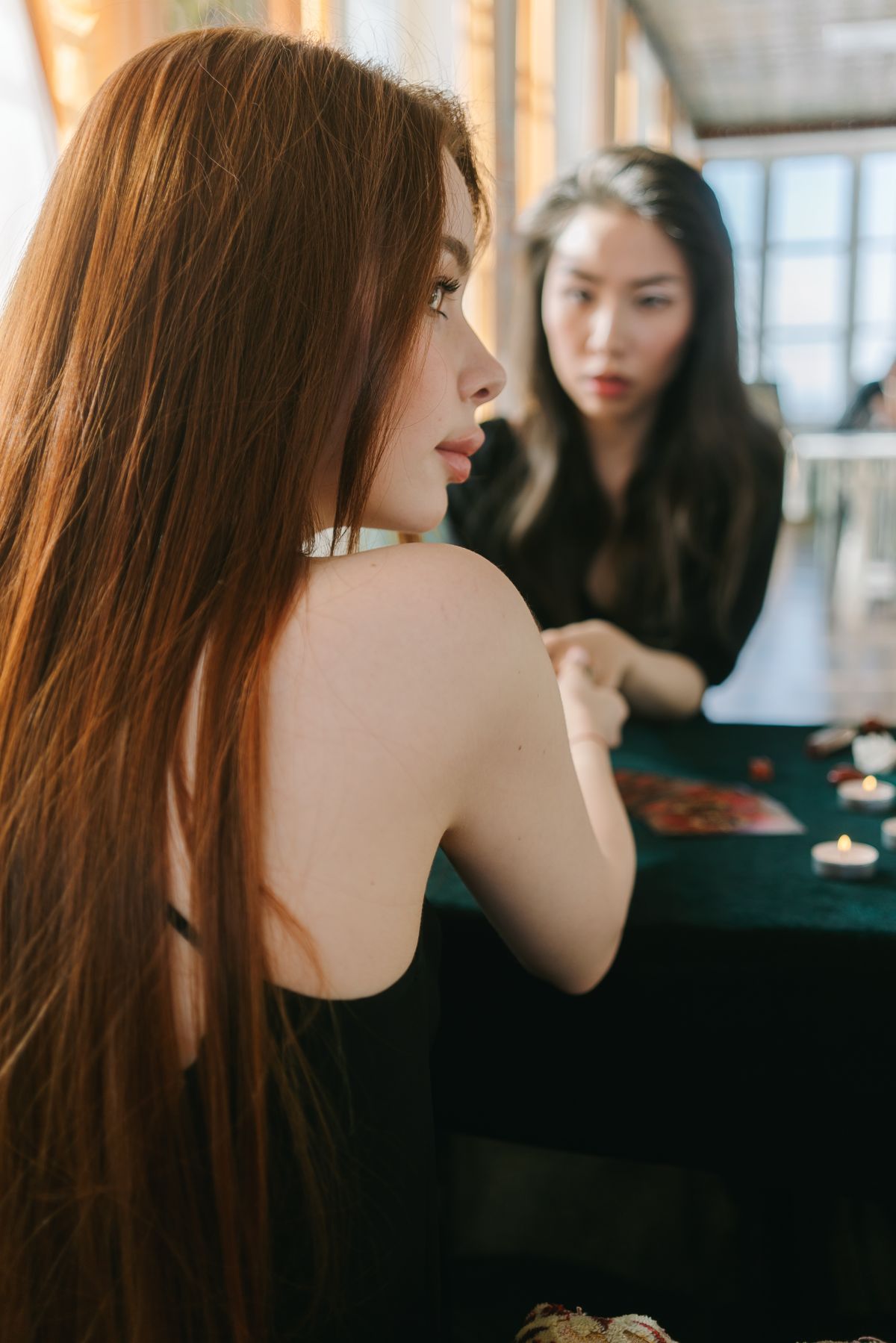 Mulher em leitura de tarot com velas e cristais