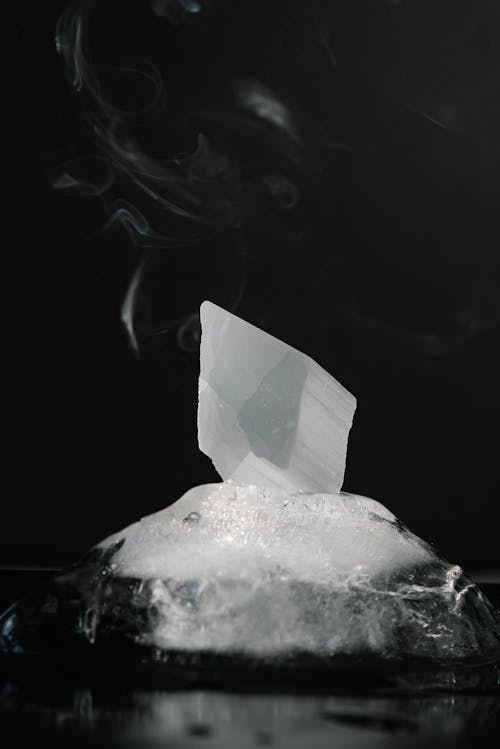 Free Black and white of crystal in piece of melting ice with steam against black background Stock Photo