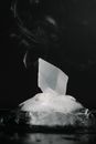Black and white of crystal in piece of melting ice with steam against black background