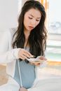 Serious Asian woman with palo santo and seashell preparing for spiritual stress relief session