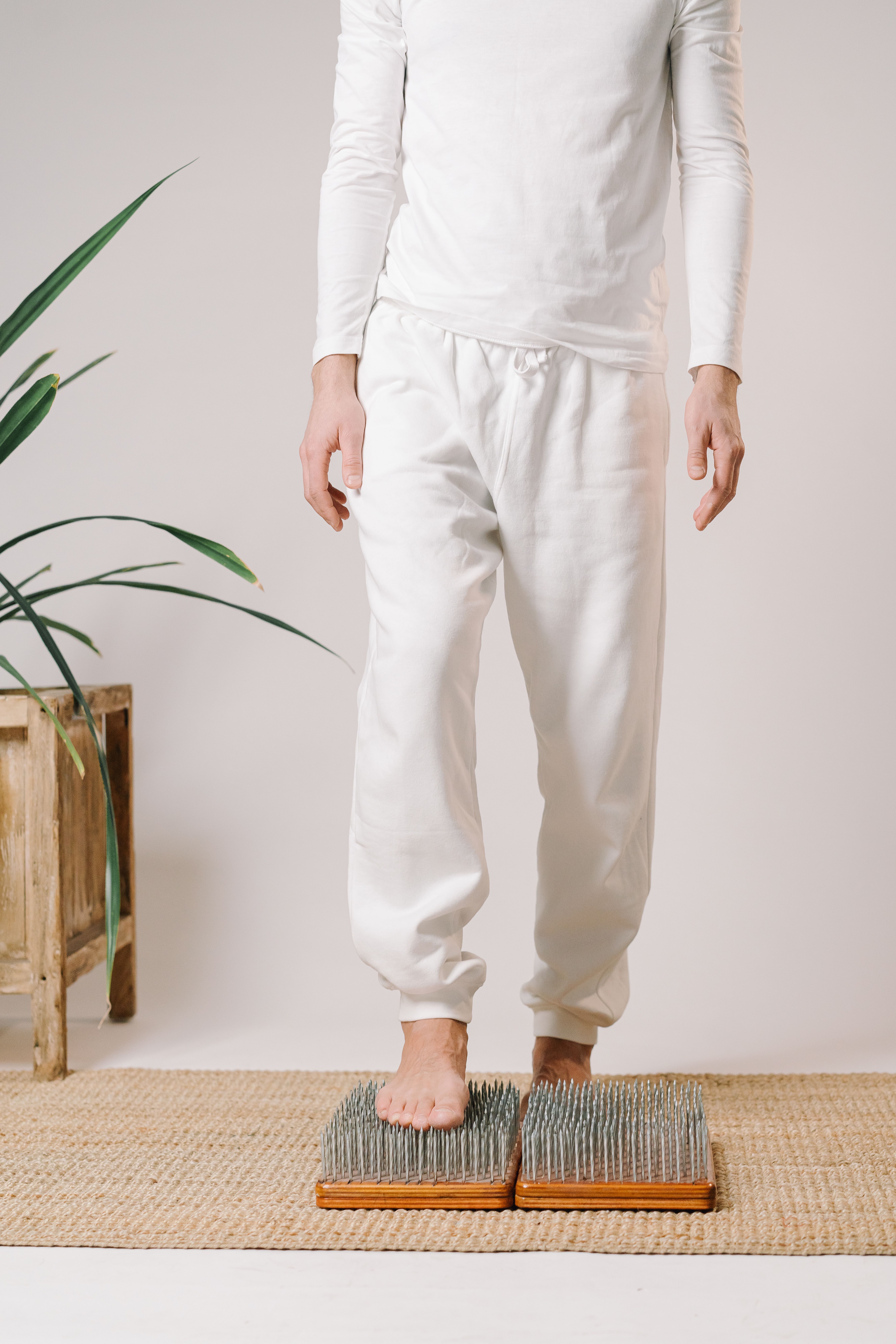 Crop unrecognizable barefoot male yogi practicing nail standing during spiritual practice for concentration and strength of spirit