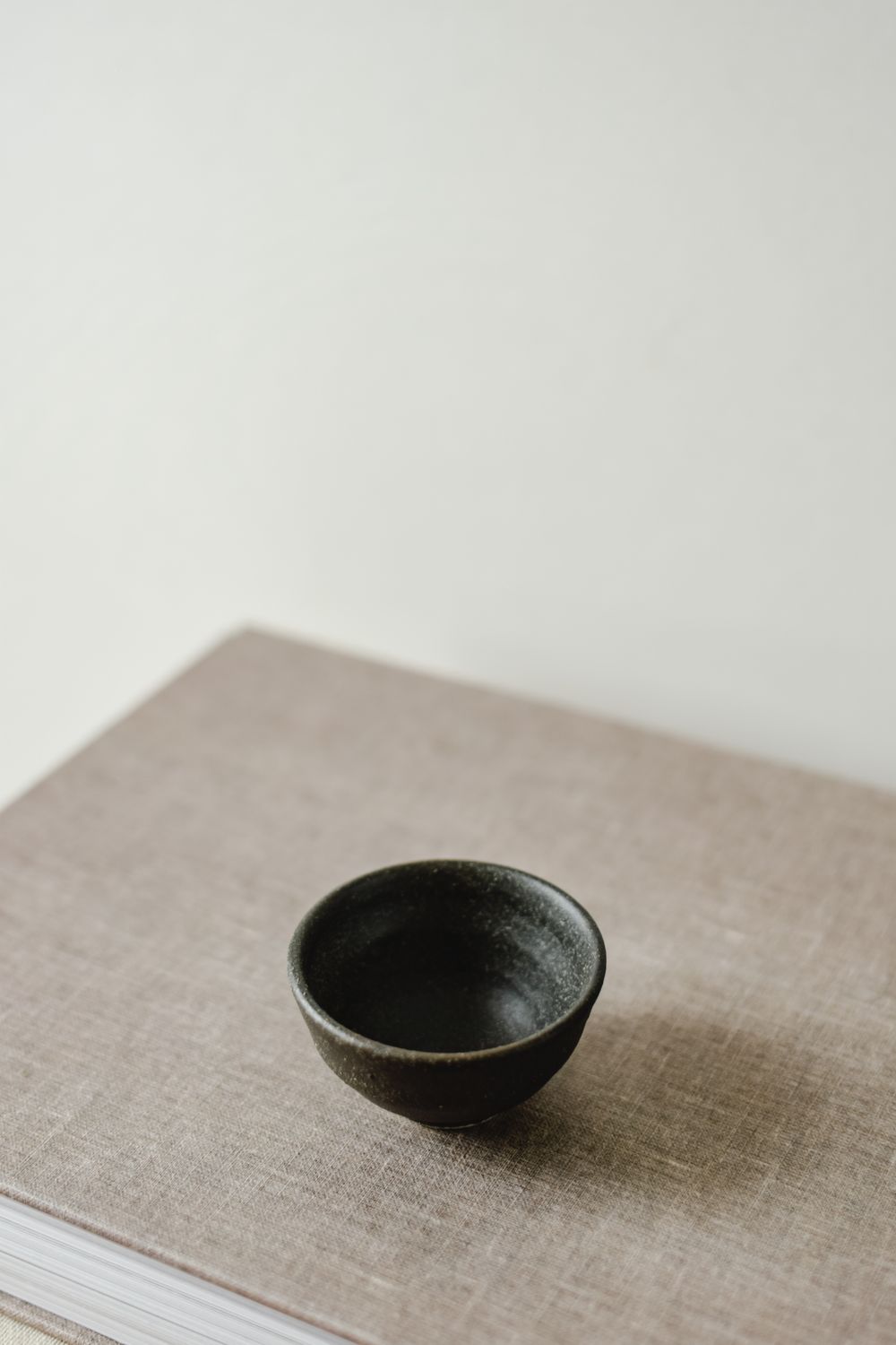 Minimal handmade ceramic bowl on a neutral linen surface