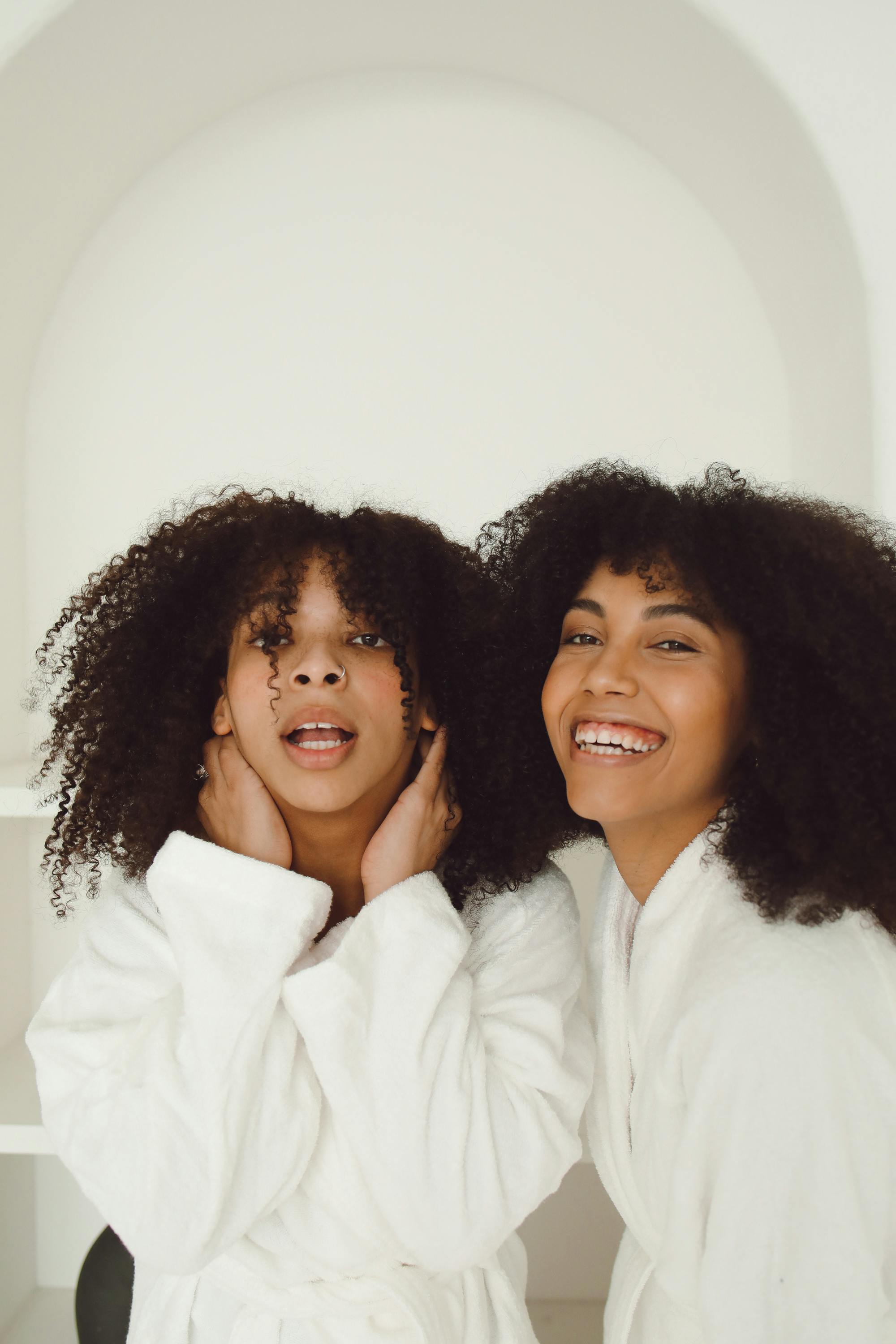 smiling sisters wearing white bathrobes