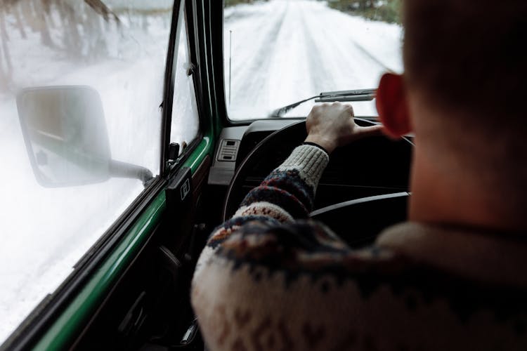 A Man Driving A Motor Vehicle