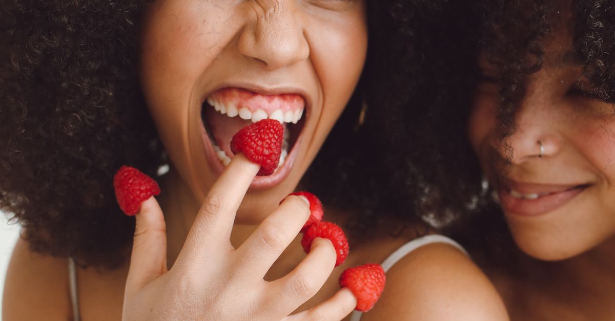 Woman Holding Raspberry A Smiling Woman with Raspberries on Her Fingers · Free Stock Photo