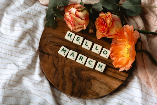 Free Top View of Scrabble Tiles on Wooden Surface near Flowers Stock Photo
