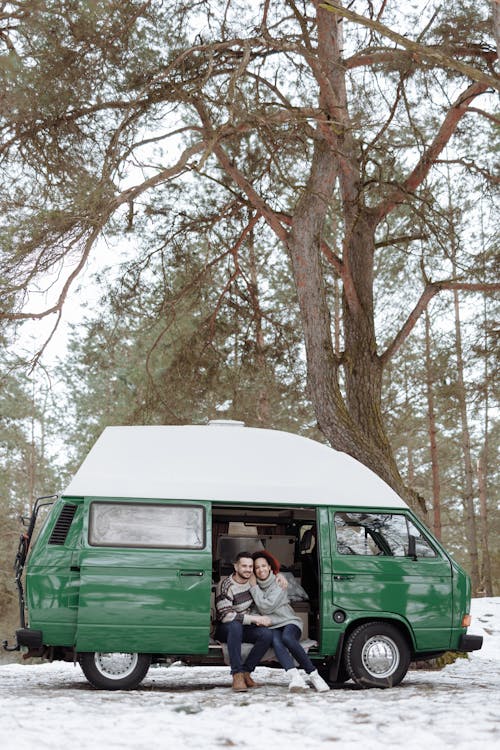 Free Couple on a Green Van in the Nature Stock Photo