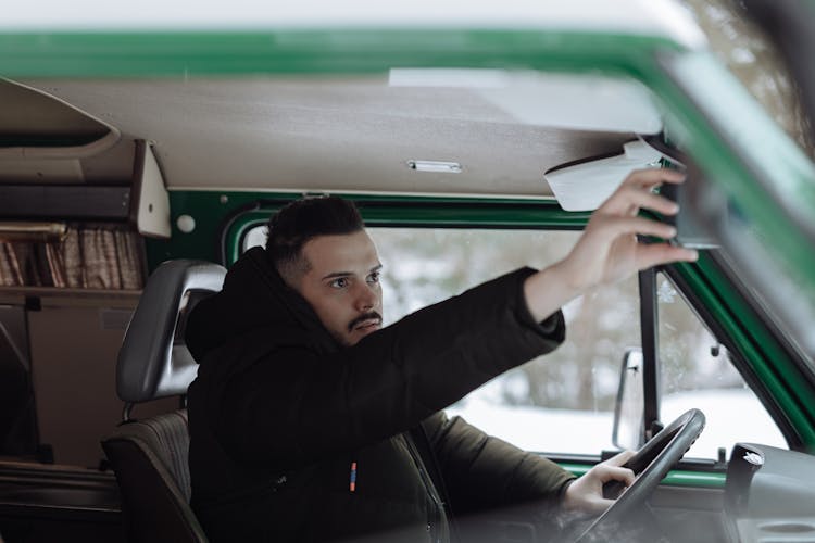 Man In Black Jacket Fixing The Rear View Mirror