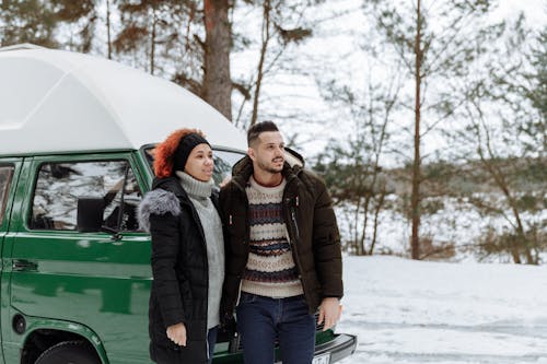 Free Couple In Front of a Green Van while in the Snowy Forest Stock Photo