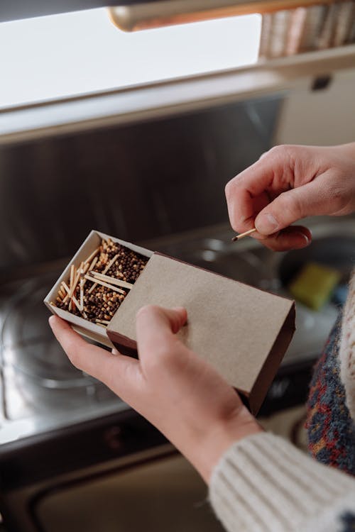 A Person's Hand Holding a Box of Match Sticks