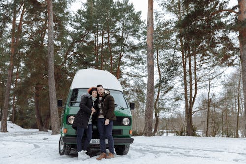 Free Couple In Front of a Green Van while in the Forest Stock Photo