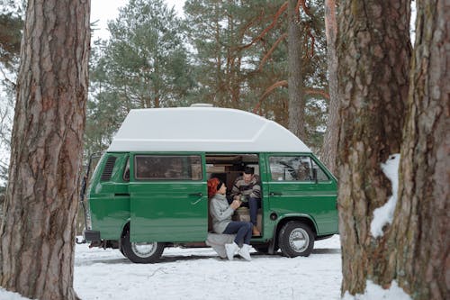 Free Couple Sitting Inside a Van Having Hot Drink Stock Photo