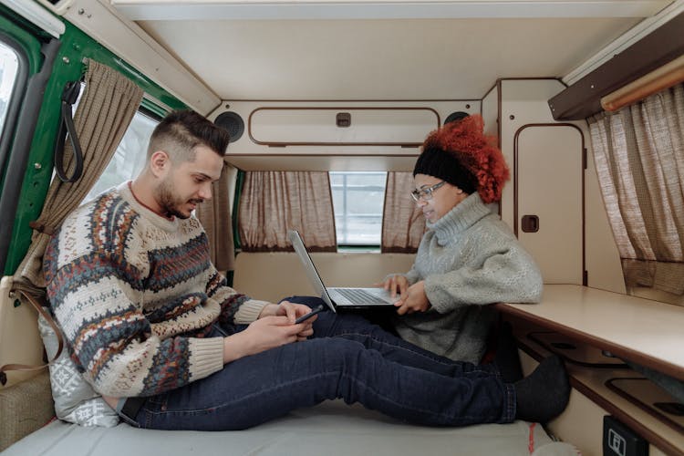 A Couple Remote Working From A Campervan