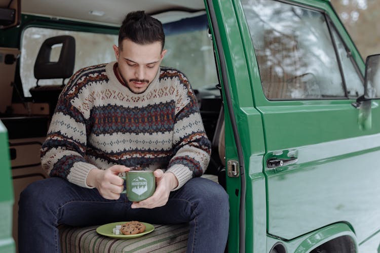 A Man Having Coffee While SItting In A Van