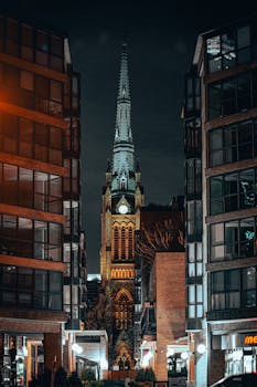 A stunning night view of St. James Cathedral framed by modern buildings in downtown Toronto.
