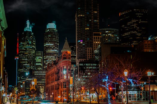 Vibrant night view of downtown Toronto skyline featuring the iconic CN Tower and historic buildings.