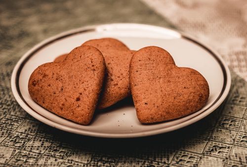 Free From above yummy sweet heart shaped cookies placed on plate served on table in kitchen Stock Photo