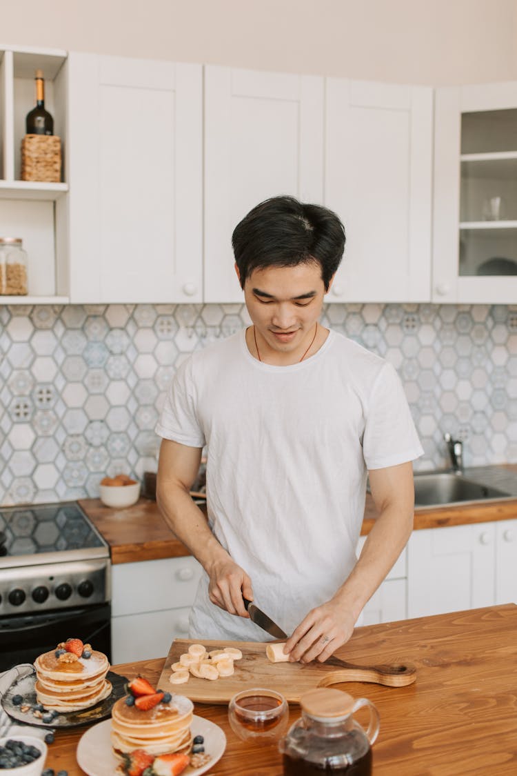 Man In White Shirt Slicing Banana