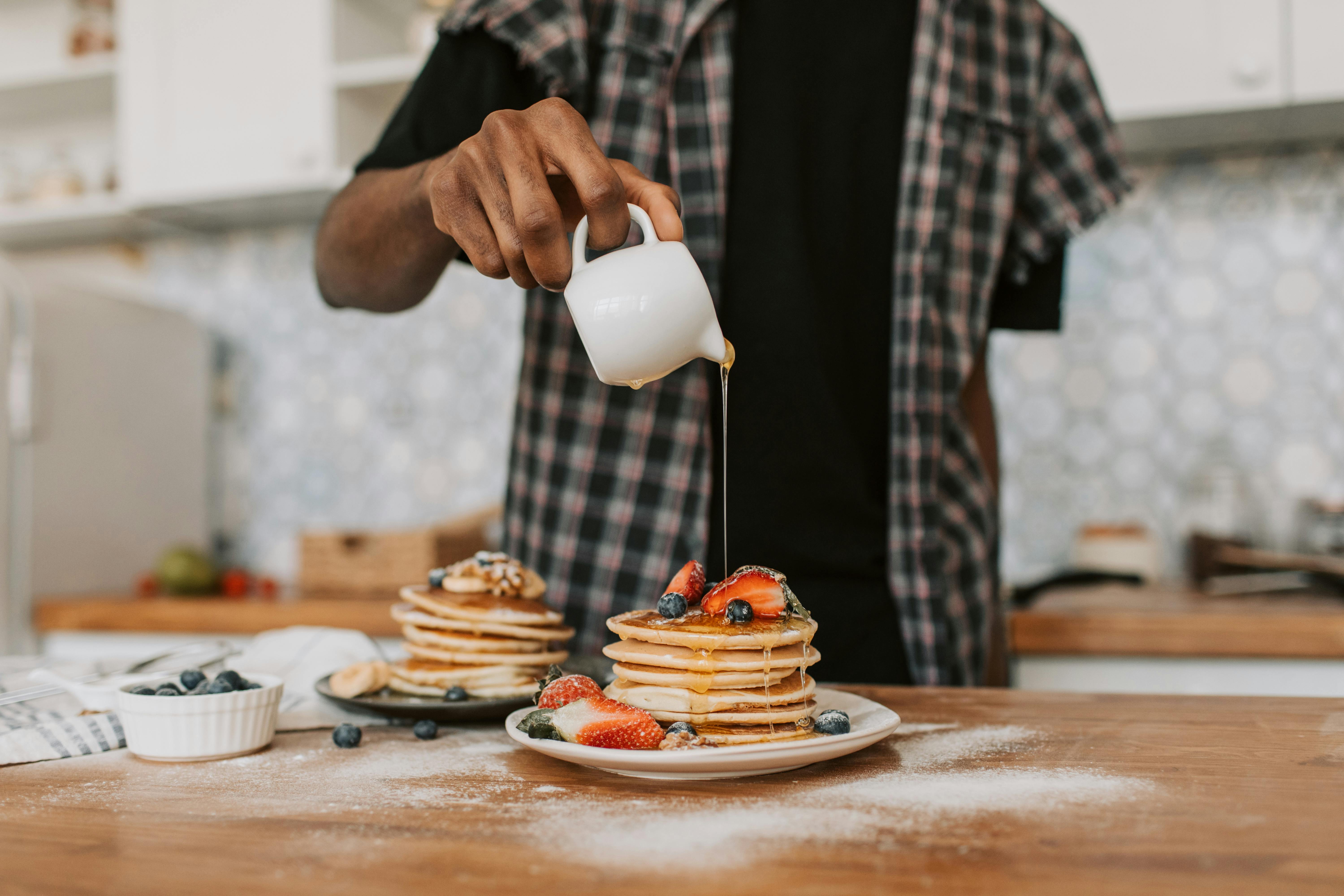 La pentola per le mani con pancake, cucinando a casa Foto stock - Alamy