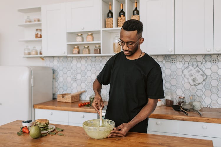 A Man Mixing Batter In A Bowl