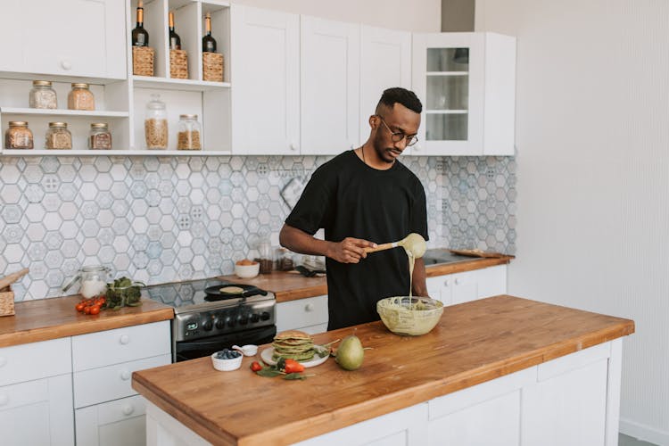 A Man Mixing Batter In A Bowl