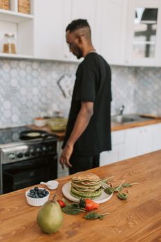 Man cooking pancakes in a modern kitchen setting. Fresh and healthy breakfast vibes.
