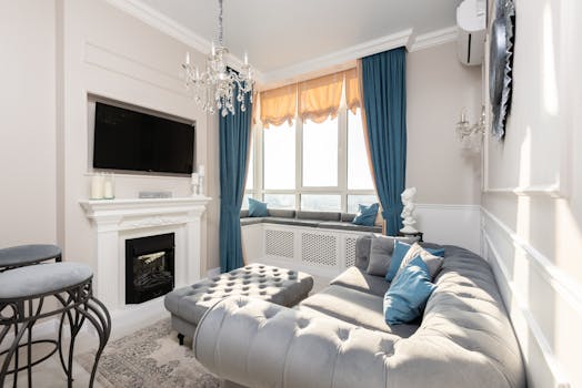 Elegant modern living room featuring plush furniture, chandelier, and stylish decor.
