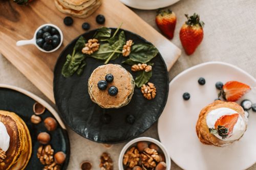Free Overhead shot of pancakes with blueberries, strawberries, and walnuts for breakfast. Stock Photo