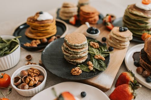 Free Selection of pancakes with fruit and nuts on plates, perfect for breakfast. Stock Photo
