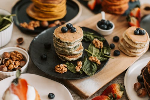Close-Up Shot of Stack of Pancakes with Berries and Nuts