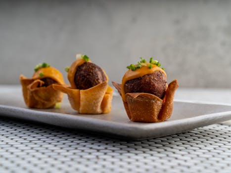 Delicious crispy appetizers garnished with cheese and herbs on a plate. Perfect for gourmet settings.