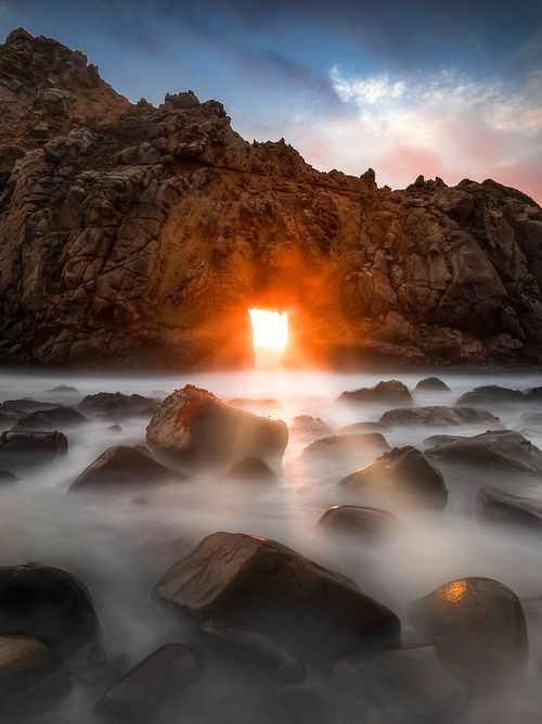 Free Sunset light through a sea arch creates a stunning scene at Pfeiffer Beach, California. Stock Photo