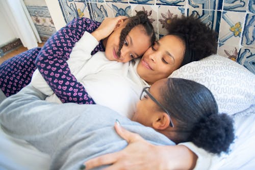 Free A Mother and Her Daughters In Pajamas Embracing Each Other Stock Photo