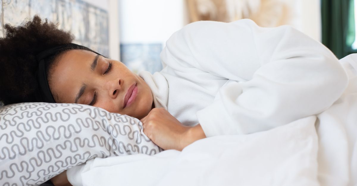 A serene woman sleeping on a patterned pillow indoors, embodying relaxation and comfort.