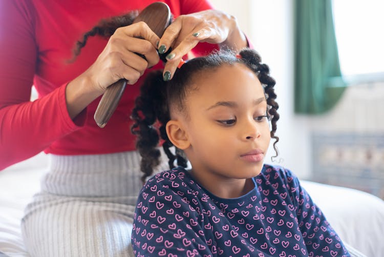 Person Fixing The Hair Of A Child