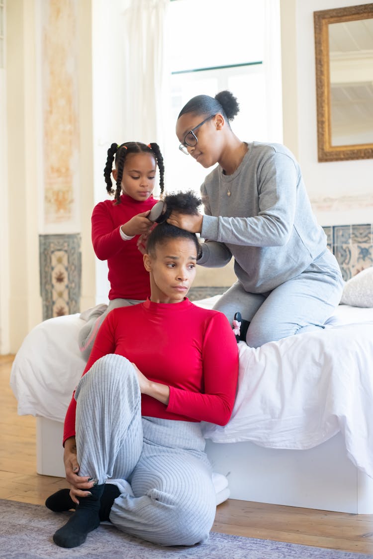 Girls Brushing The Hair Of A Woman