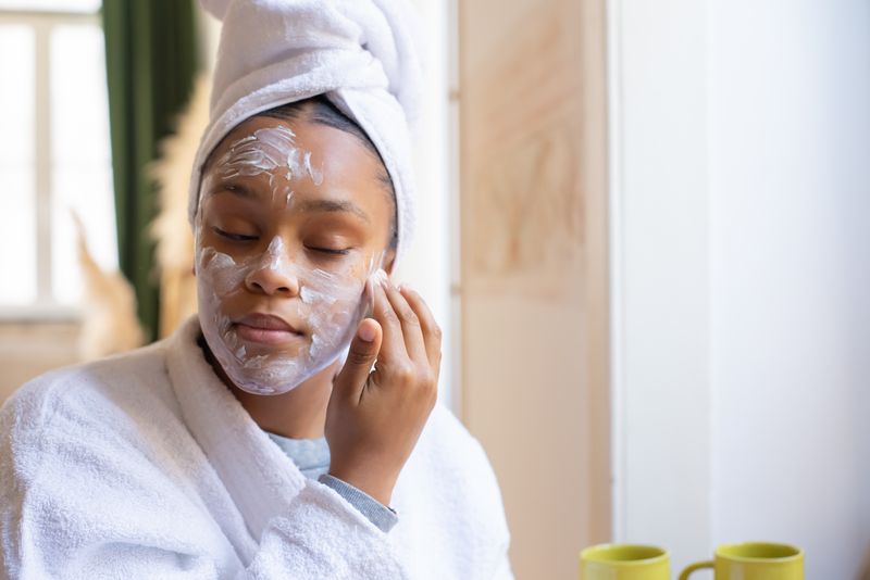 Teenage girl applying facial cream as part of her skincare routine